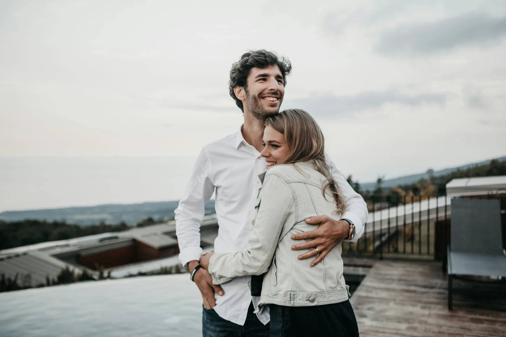 A couple embracing on a rooftop terrace at dusk